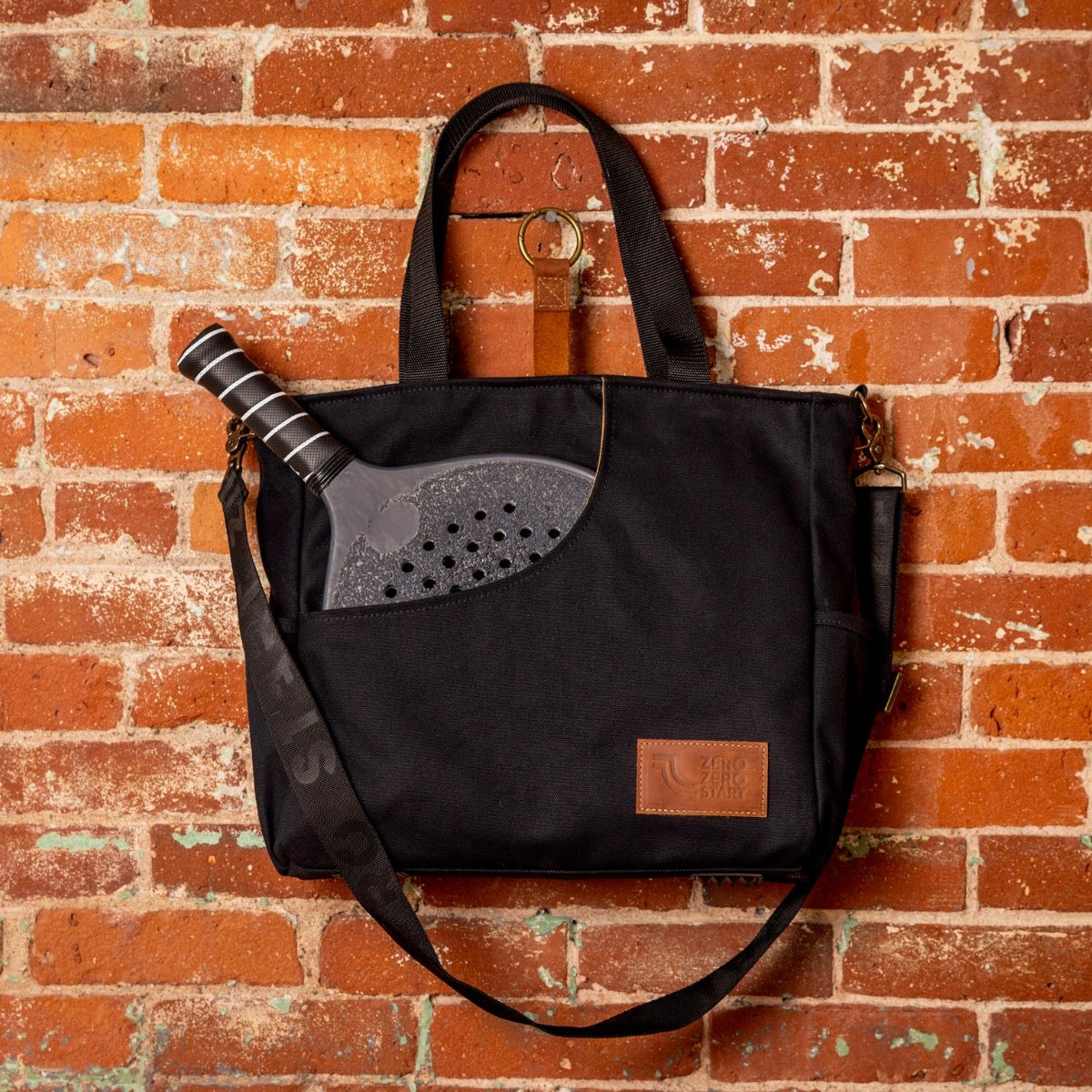 Premium Black Paddle Bag for Pickleball Hanging on a Hook on Brick Wall